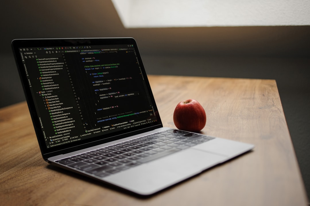 Laptop displaying code with an apple nearby